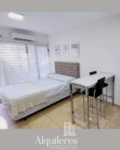 1 dormitorio con cama, escritorio y mesa en suipacha 437 en Rosario