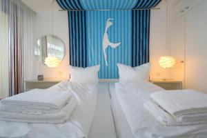 a bedroom with two beds and a mirror at Haus Metropol 175 OB in Westerland (Sylt)