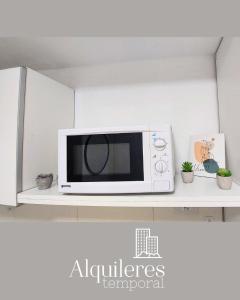 un microondas sentado en un estante en una cocina en suipacha 437 en Rosario