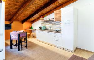 uma cozinha com armários brancos e uma mesa em Lovely Home In San Marco Castellabate With Jacuzzi em San Marco di Castellabate