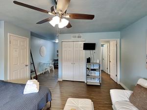 - un salon avec un lit et un ventilateur de plafond dans l'établissement Cozy Coconut, à Port Aransas