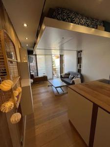 uma cozinha e sala de estar com um sofá e uma mesa em Studio cosy et moderne aux pieds des pistes em LʼHuez