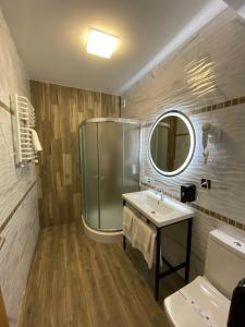 a bathroom with a shower and a sink and a mirror at VATRA HOTEL in Ternopilʼ