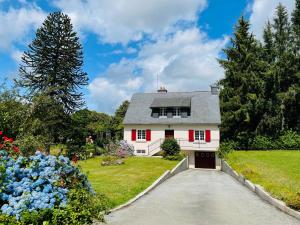 Casa blanca con persianas rojas y entrada en Maison au calme grand jardin privé aire de jeux Lac de Guerledan en Plouguernével