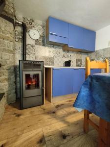 cocina con armarios azules y fogones en Hameau Gubioche, casa vacanze, en Chambave