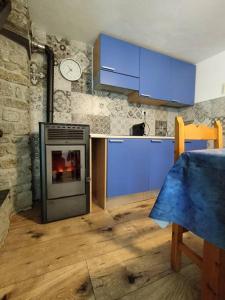 a kitchen with blue cabinets and a stove at Hameau Gubioche, casa vacanze in Chambave