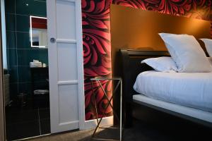 een slaapkamer met een bed en een rode en zwarte muur bij LOGIS Hôtel Borel in Duinkerke