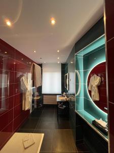 a bathroom with red and blue walls and a mirror at LOGIS Hôtel Borel in Dunkerque