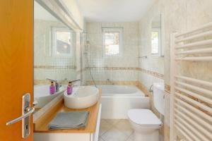 y baño con lavabo, bañera y aseo. en Lakeview Bled Heaven Apartments, en Bled