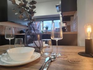 - une table avec des verres à vin, un bol et un vase dans l'établissement Stay @ The Old Bank Apartments, Burton on Trent, à Burton-on-Trent