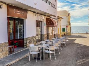 a row of tables and chairs outside of a building at Hostal Ca'n Pep in Sa Ràpita