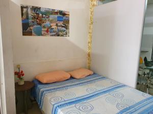 a small room with two pillows on a bed at Kitnet no 1º Piso, a 300m da Praia do Morro in Guarapari