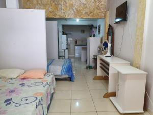 a room with a bedroom with a bed and a kitchen at Kitnet no 1º Piso, a 300m da Praia do Morro in Guarapari