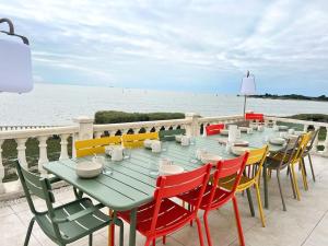 een groene tafel en stoelen met uitzicht op de oceaan bij La Villa du Chay - Villa d'exception in Angoulins