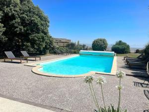 een zwembad met banken eromheen in een tuin bij La Villa du Chay - Villa d'exception in Angoulins