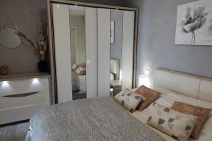 1 dormitorio con cama y espejo grande en L'Ozen, en Fréland