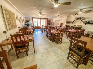 un restaurante con mesas de madera y sillas en una habitación en Hostal Ca'n Pep en Sa Ràpita