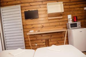 Zimmer mit 2 Betten, einem TV und einem Kühlschrank. in der Unterkunft Gîte Rose Doudou in Mamoudzou