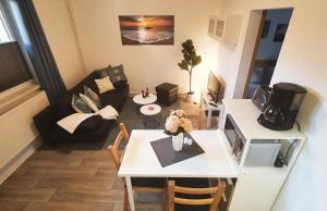 een kleine woonkamer met een witte tafel en een woonkamer bij Hanni, wenige Minuten zum Strand in Warnemünde