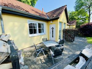 a patio with a table and chairs in front of a house at Hanni, wenige Minuten zum Strand in Warnemünde