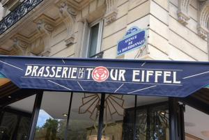 a blue sign for a restaurant in front of a building at Eiffel Tower Oasis 30m from Eiffel Tower in Paris