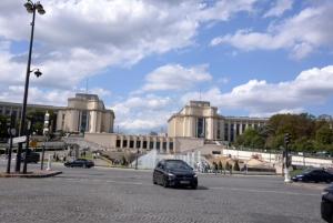 a car driving down a street in front of a building at Eiffel Tower Oasis 30m from Eiffel Tower in Paris
