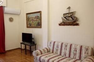 a living room with a couch and a tv at Omonoia Classic Manor in Athens