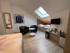 a room with a bed and a desk and chairs at B&B De Groene Gast in Montfort