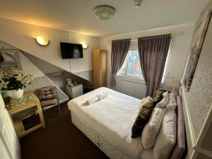 a hotel room with a bed and a window at Ocean Road Rooms in South Shields