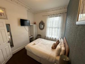 Schlafzimmer mit einem Bett und einem Fenster in der Unterkunft Ocean Road Rooms in South Shields