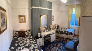 1 Schlafzimmer mit 2 Betten, einem Waschbecken und einem Spiegel in der Unterkunft Ocean Road Rooms in South Shields