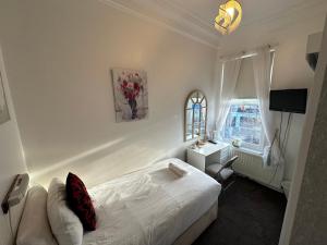 a bedroom with a bed and a desk and a window at Ocean Road Rooms in South Shields +12 photos
