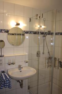 a white bathroom with a sink and a shower at Ferienwohnung Keller in Hagnau