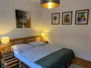 een slaapkamer met een bed met twee lampen en foto's aan de muur bij BELIEBT: Zentrales & ruhiges Innenstadtapartment in Halle an der Saale