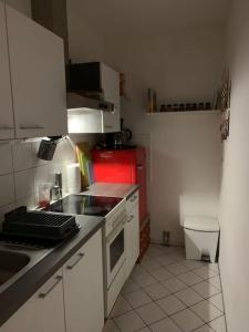 una pequeña cocina con fregadero y nevera roja en BELIEBT: Zentrales & ruhiges Innenstadtapartment, en Halle an der Saale