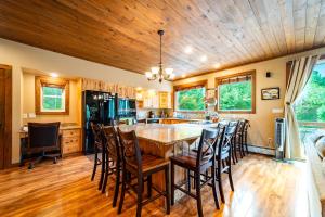 a kitchen with a wooden ceiling and a table with chairs at Large Luxury Home, Close to Whiteface, Lake Placid in Wilmington +55 photos
