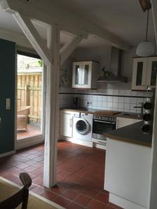 a kitchen with a stove and a washer and dryer at Lüttje Ferienhuus in Tönning +14 photos