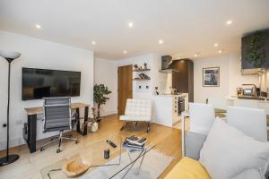 a living room with a couch and a desk at Urban Oasis with Views in Old St in London