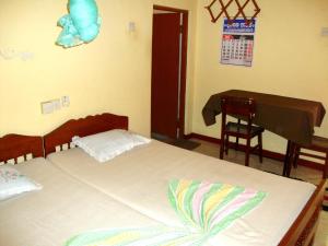 A bed or beds in a room at Chamara Guest House