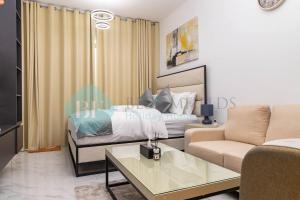 a living room with a bed and a couch at Lavish Studio In Oasis in Al Qurayyah