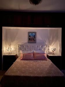- une chambre avec un grand lit blanc et deux lampes dans l'établissement Dar louzir à Tazarka, à Tazarka