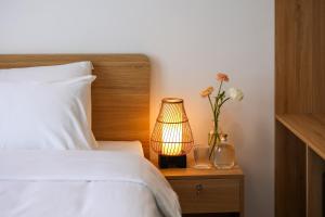 un letto con una lampada su un tavolo con fiori di Lemi - Homestay in Hue a Hue
