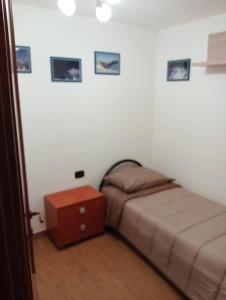Habitación pequeña con cama y mesita de noche en Appartamento Biolley, en Morgex