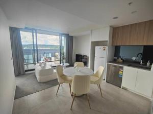 a kitchen and living room with a table and chairs at Brand New 2B1B Apt @ Inner North of Canberra in Canberra