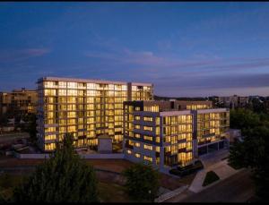 a large apartment building with lights on at night at Brand New 2B1B Apt @ Inner North of Canberra in Canberra
