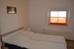 a white bed in a room with a window at Immensee App B in Ehst