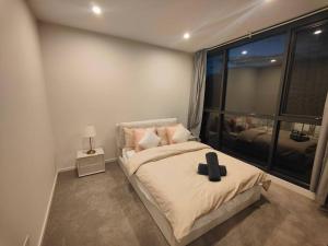 a bedroom with a bed with a black cross on it at Brand New 2B1B Apt @ Inner North of Canberra in Canberra