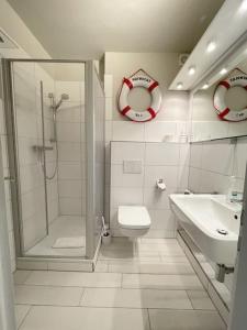a bathroom with a shower and a toilet and a sink at Nordseewölckchen 1 in Katingsiel
