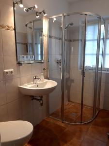 uma casa de banho com um chuveiro e um lavatório. em Nordseewölkchen 3 em Katingsiel