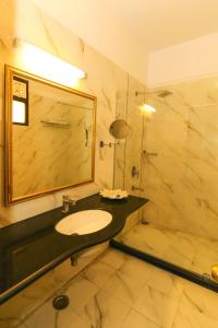 ein Badezimmer mit Waschbecken, Spiegel und Dusche in der Unterkunft Hotel Boheda Palace Udaipur in Udaipur